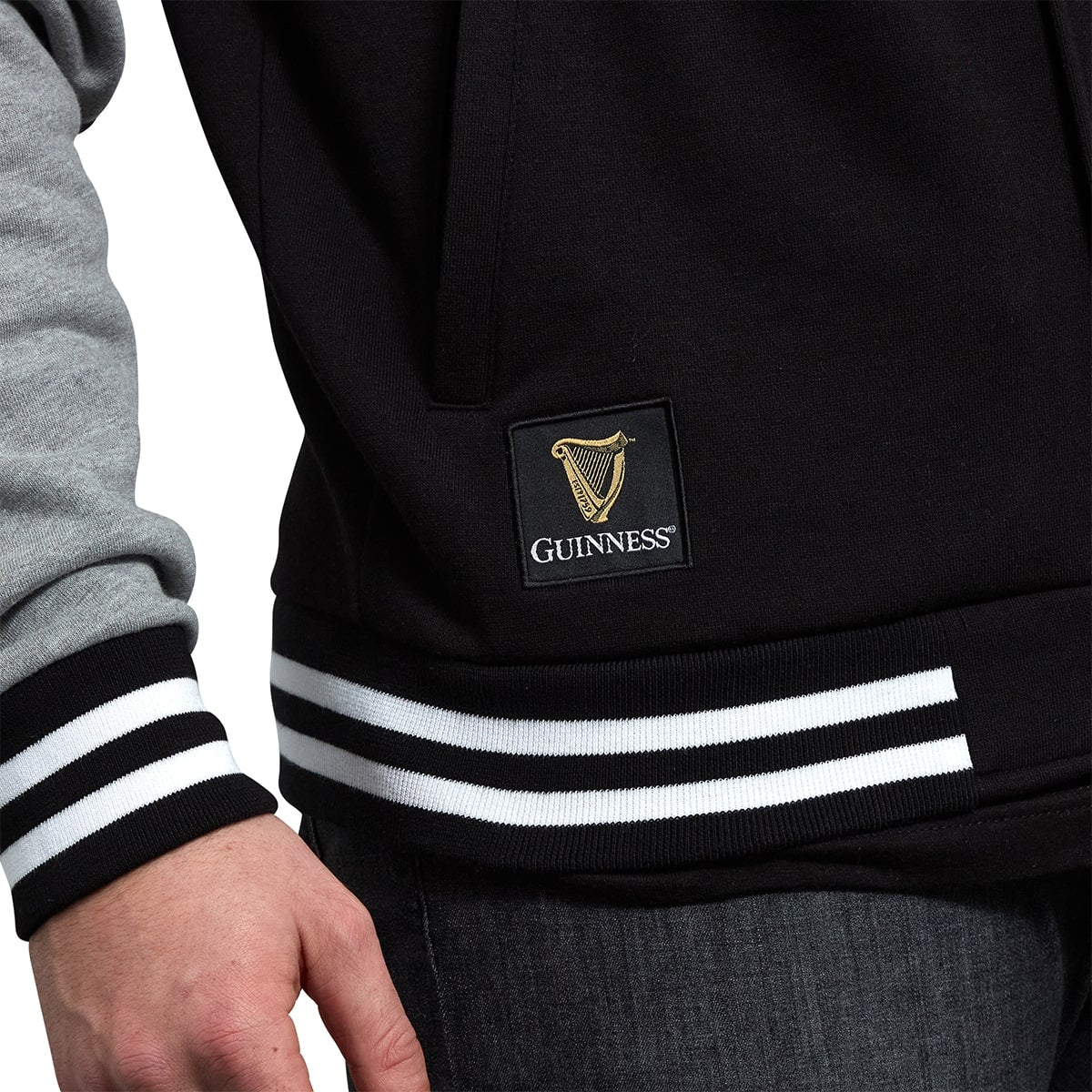 A man stylishly donning a Guinness Letterman Jacket.
