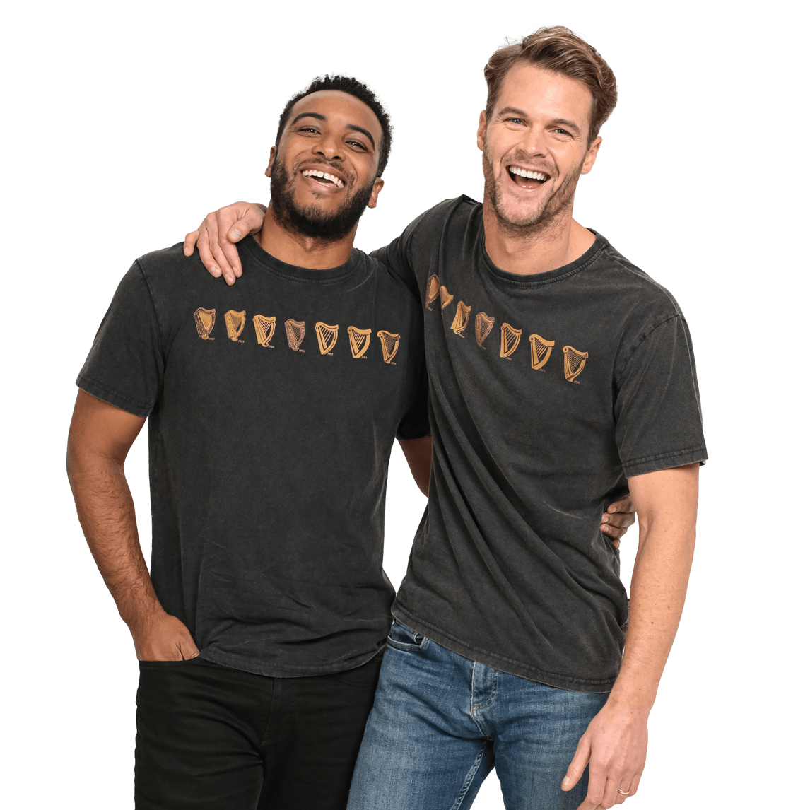 Two men are smiling and standing close together, with one man's arm around the other's shoulder. They are both wearing black Guinness Black Evolution Harp Premium Tees adorned with a series of brown, shield-like symbols on the front.