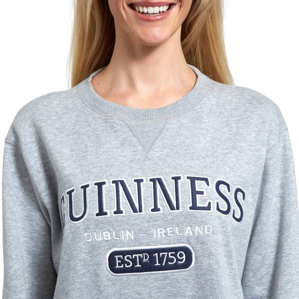 A woman wearing a Guinness Grey Crew Neck Sweatshirt.