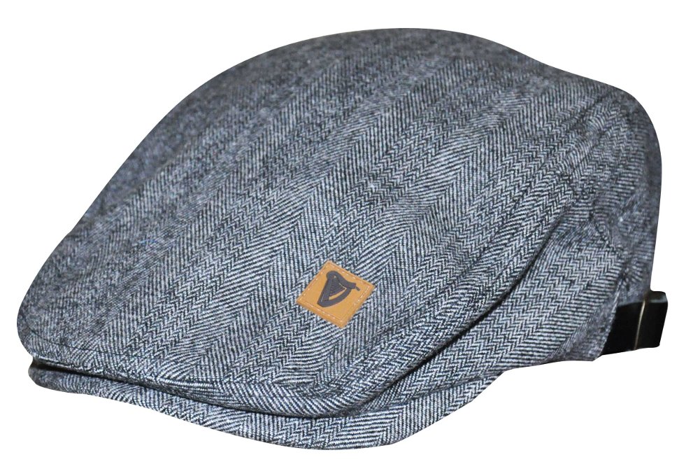 A Guinness Classic Tweed Buckle Ivy Flat Cap, a wardrobe essential featuring a grey hat with a brown patch on it.