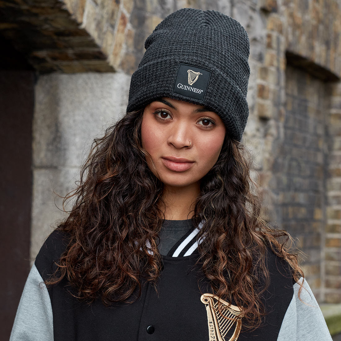 A young woman wearing a Guinness Thinsulated Beanie hat.