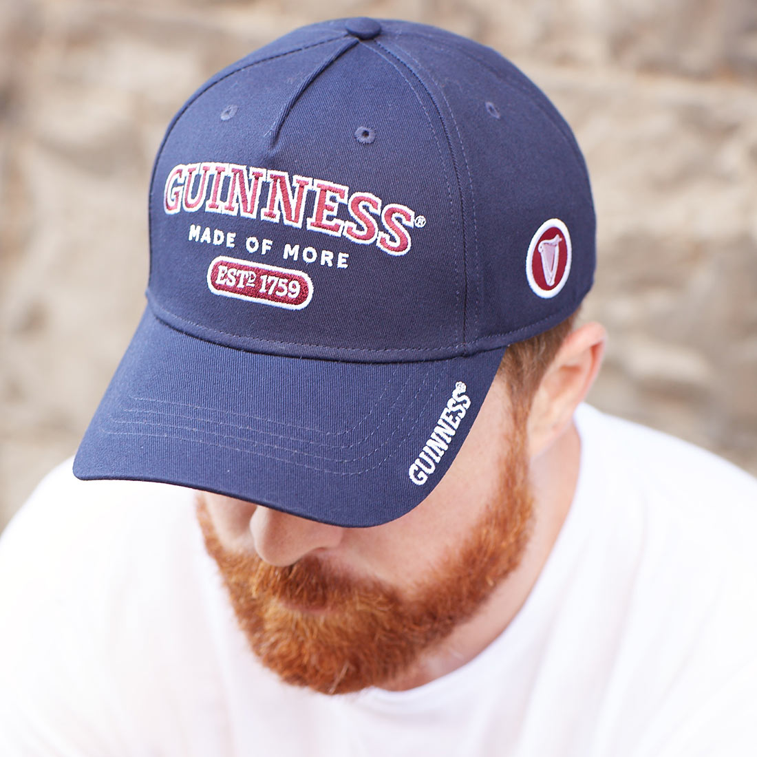 A man with a beard wearing an adjustable Guinness Signature Blue Baseball Cap.