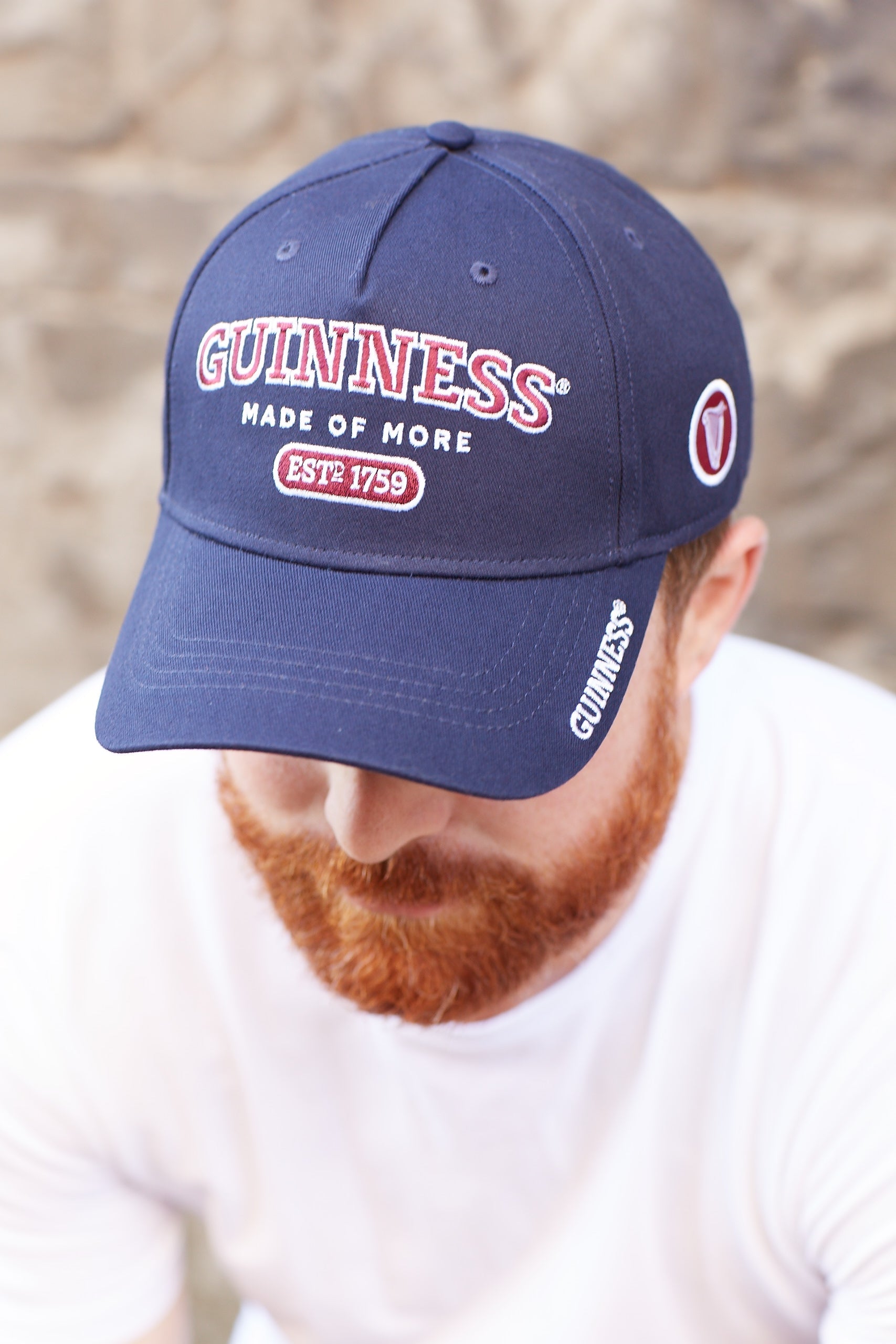 An adjustable man, donning a Guinness Signature Blue Baseball Cap Adjustable and sporting a beard.