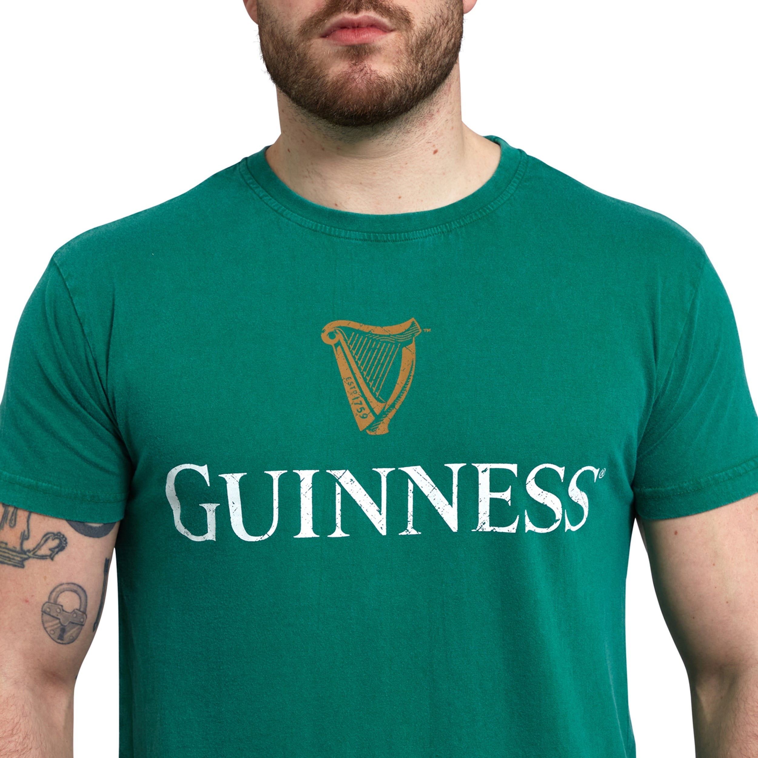 A Guinness lover sporting a Green Guinness Harp Premium Tee from Guinness Webstore US with a loose fit, proudly displaying the iconic harp logo on the chest.